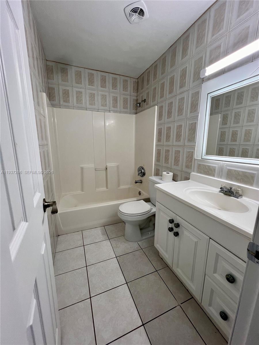 11950 Southwest 199th Street, Unit 1 Miami, FL 33177 - Photo 11 of 30 a bathroom with a sink a toilet and shower