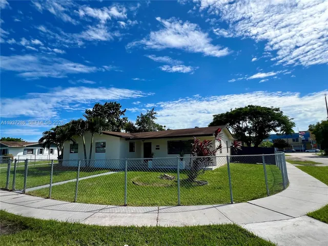 a view of a house with a big yard and a large tree
