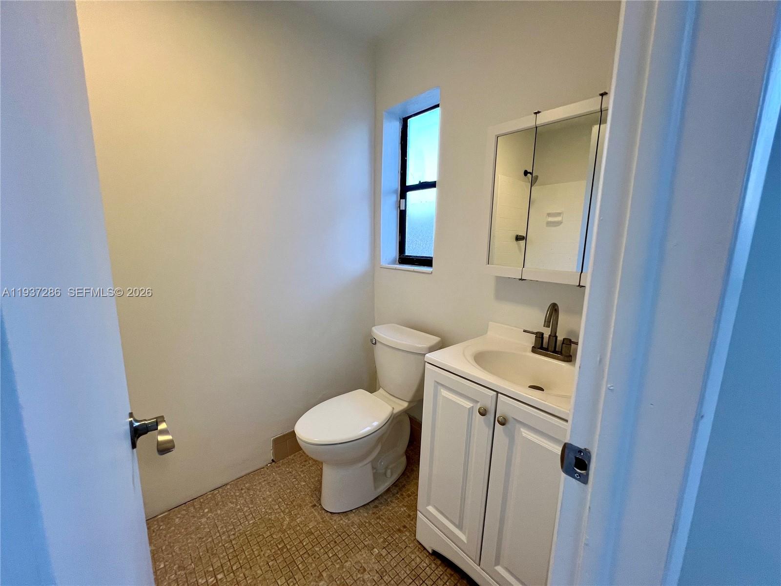 11950 Southwest 199th Street, Unit 1 Miami, FL 33177 - Photo 21 of 30 a bathroom with a sink toilet and vanity