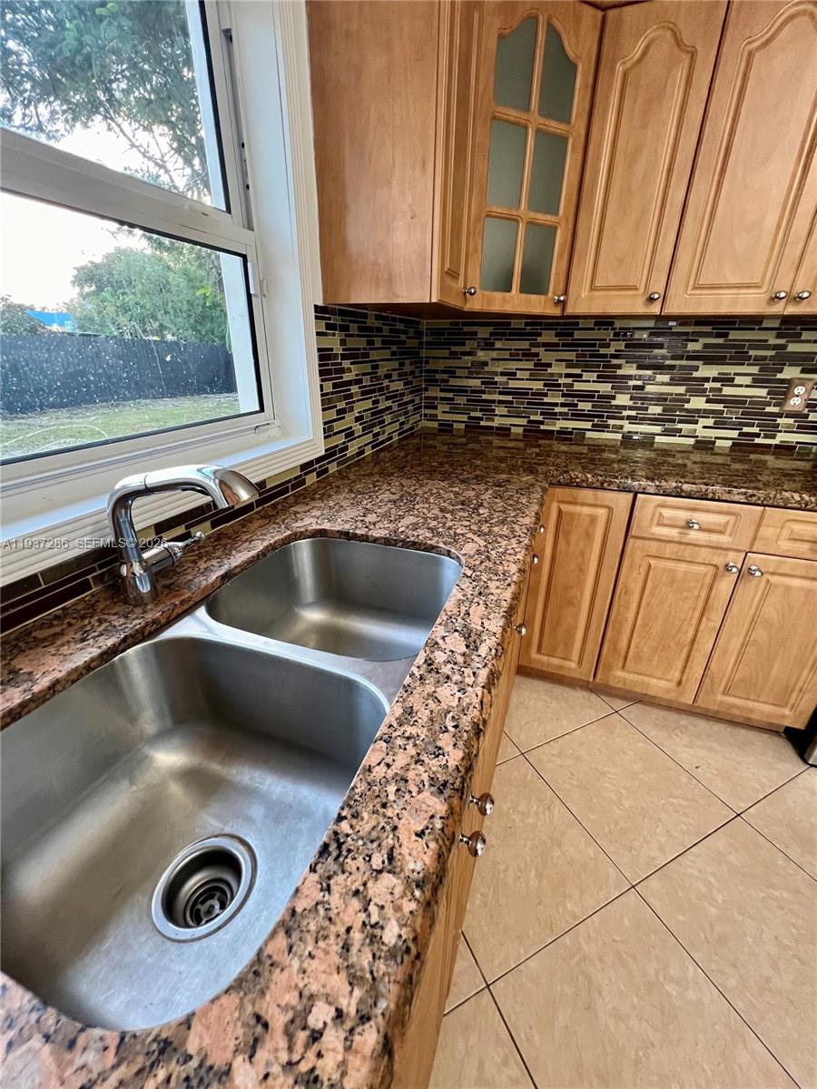11950 Southwest 199th Street, Unit 1 Miami, FL 33177 - Photo 26 of 30 a view of kitchen sink with granite countertop a sink and a stove