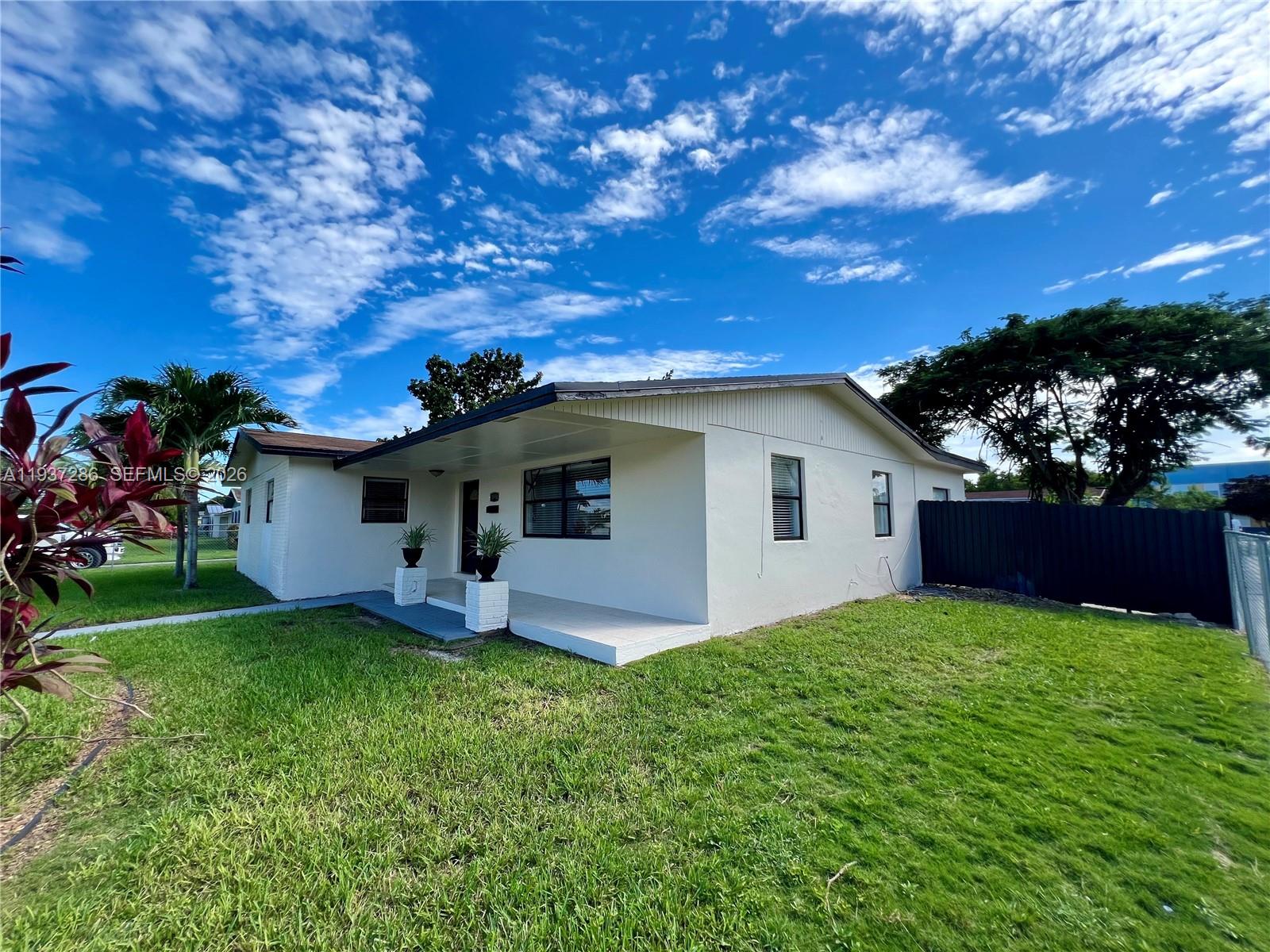11950 Southwest 199th Street, Unit 1 Miami, FL 33177 - Photo 4 of 30 a view of a house with a yard and a garden