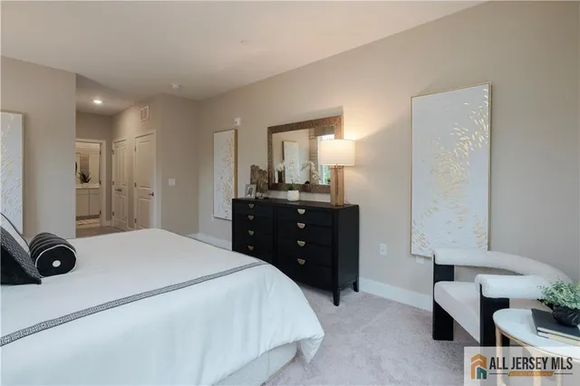 a spacious bedroom with a bed and a dresser