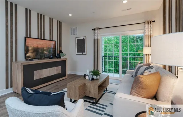 a living room with furniture a flat screen tv and a large window
