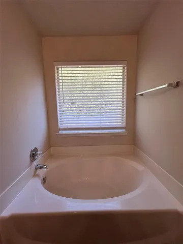 a bath tub sitting in a bathroom next to a window