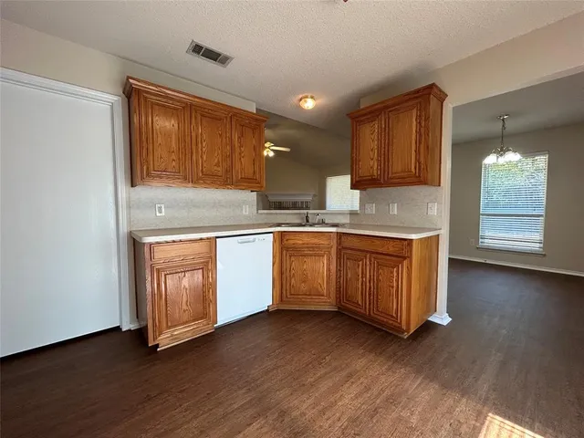 a kitchen with wooden floors and white cabinets