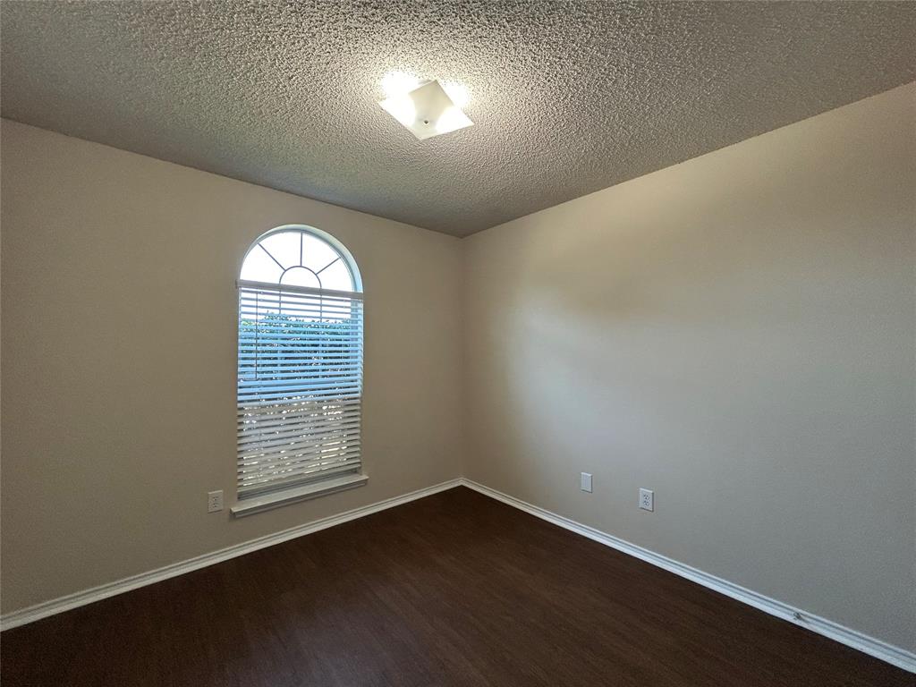 7917 Rattlers Court Arlington, TX 76002 - Photo 8 of 21 an empty room with wooden floor and windows