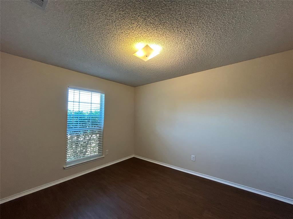 7917 Rattlers Court Arlington, TX 76002 - Photo 10 of 21 an empty room with wooden floor and windows