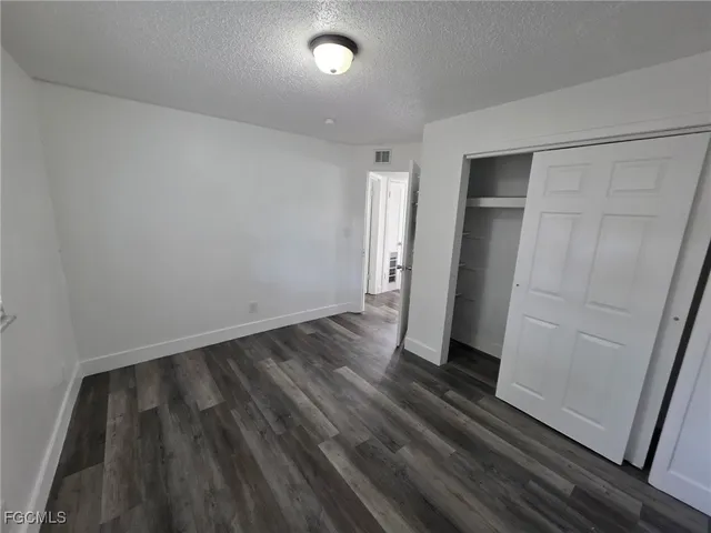 an empty room with wooden floor and entrance