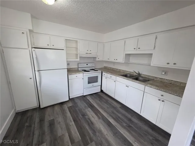 a kitchen with white cabinets and white appliances