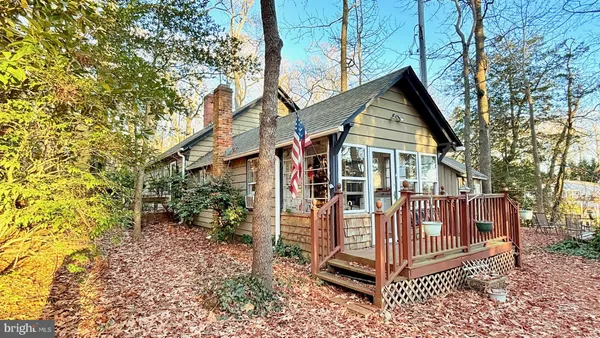 a view of a house with a yard and wooden deck