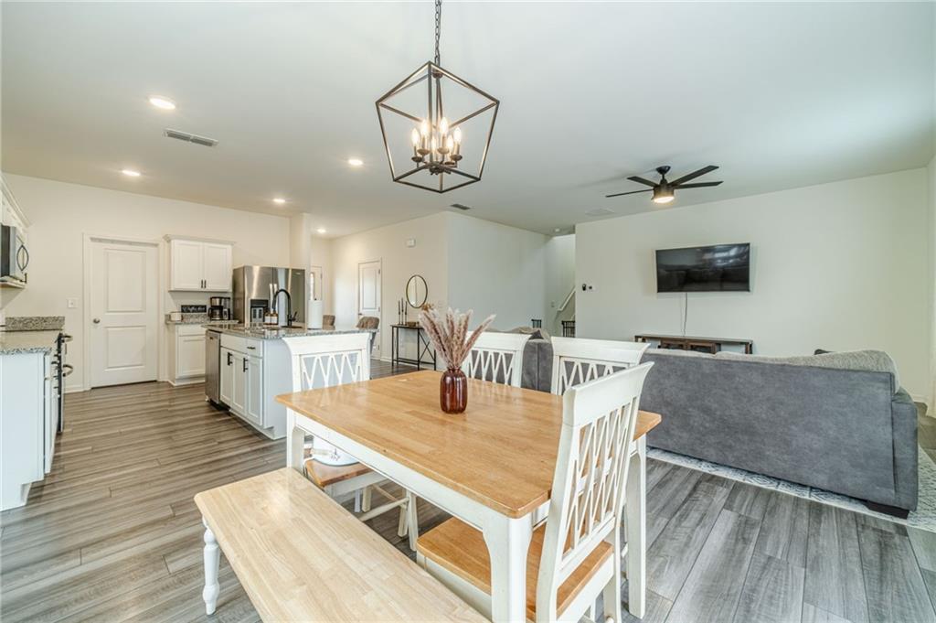 222 Knightsbridge Lane Winder, GA 30680 - Photo 11 of 39 a living room with stainless steel appliances kitchen island granite countertop furniture wooden floor and a view of kitchen