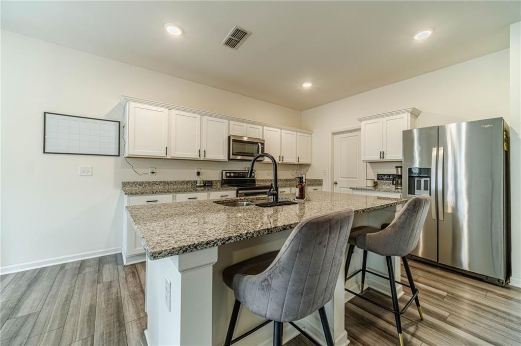 222 Knightsbridge Lane Winder, GA 30680 - Photo 9 of 39 a kitchen with stainless steel appliances granite countertop a table chairs sink refrigerator and microwave