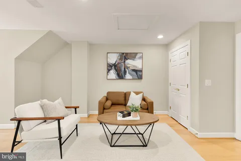 a living room with furniture and a painting on the wall