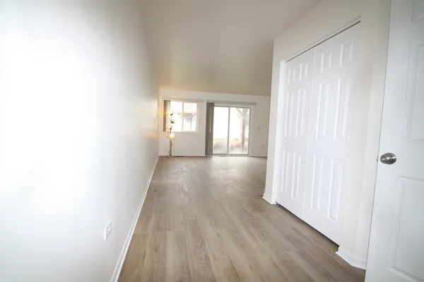a view of a hallway with wooden floor and staircase