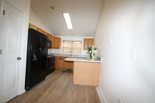 a kitchen with a refrigerator and white cabinets