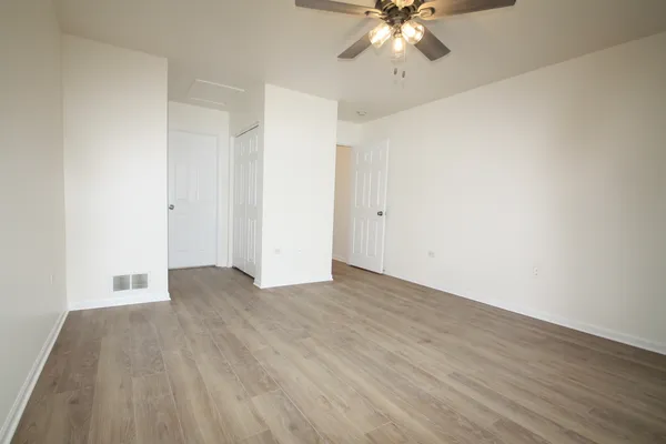 a view of an empty room with wooden floor