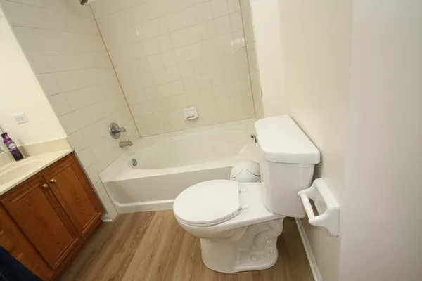 a white toilet sitting next to a bath tub