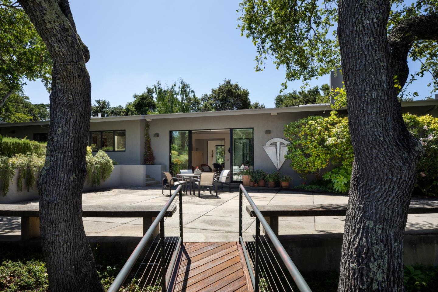 140 Degas Road Portola Valley, CA 94028 - Photo 23 of 31 a view of a patio with couches table and chairs with wooden fence and large trees