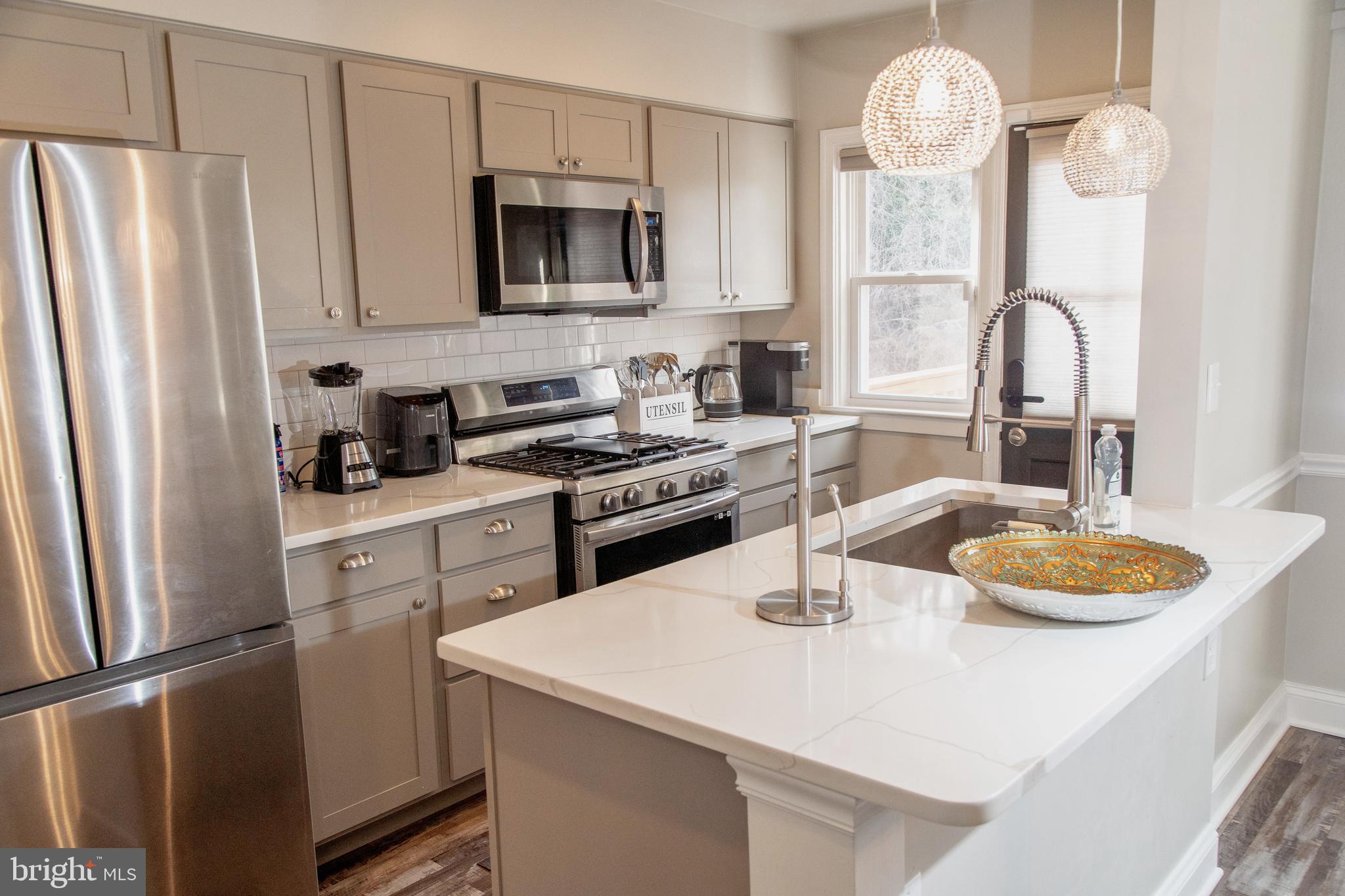 518 Random Road Baltimore, MD 21229 - Photo 7 of 29 a kitchen with a sink a stove and refrigerator