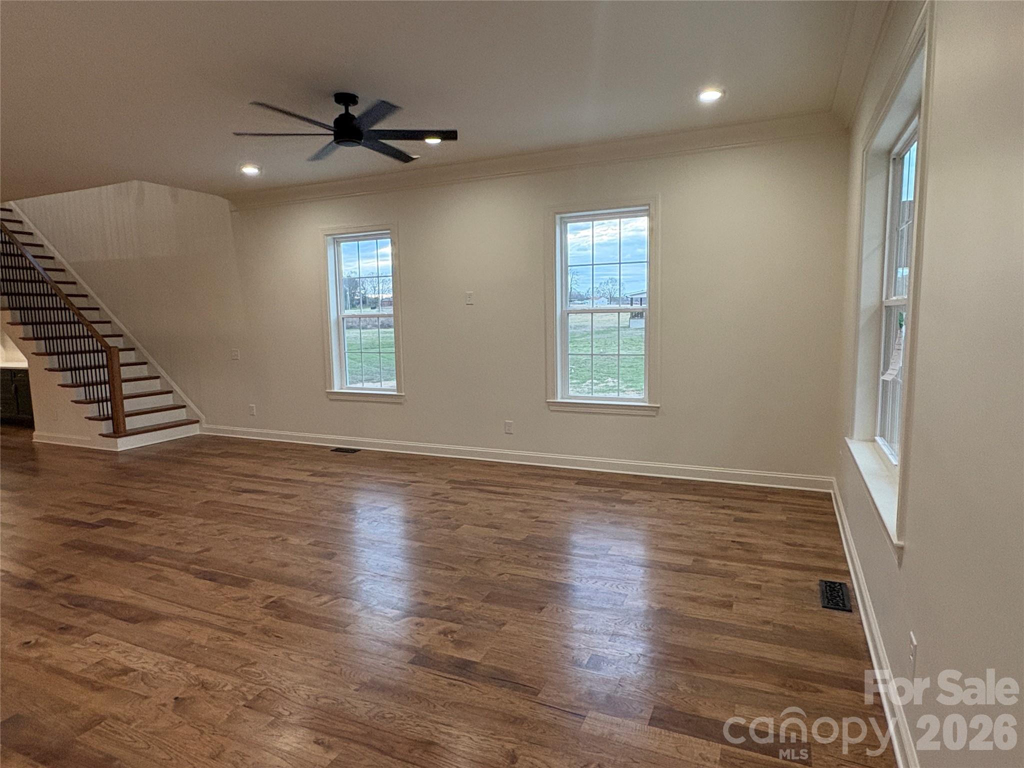 7217 Tesh Road, Unit 5 Monroe, NC 28110 - Photo 5 of 48 an empty room with wooden floor fan and windows