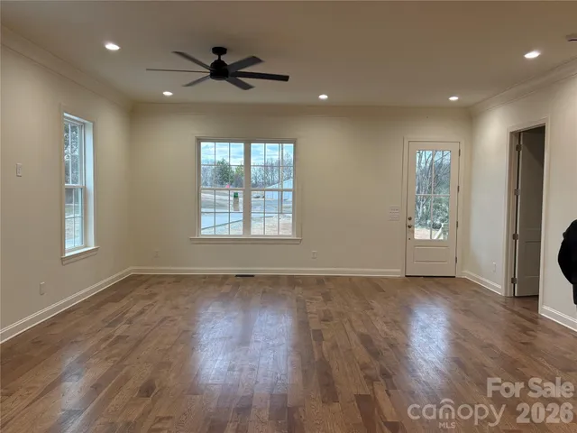 a view of a room with wooden floor and entryway