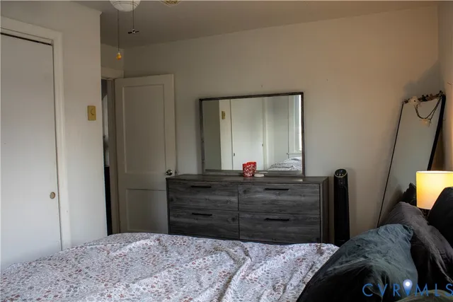 a bedroom with a bed and a mirror on dresser