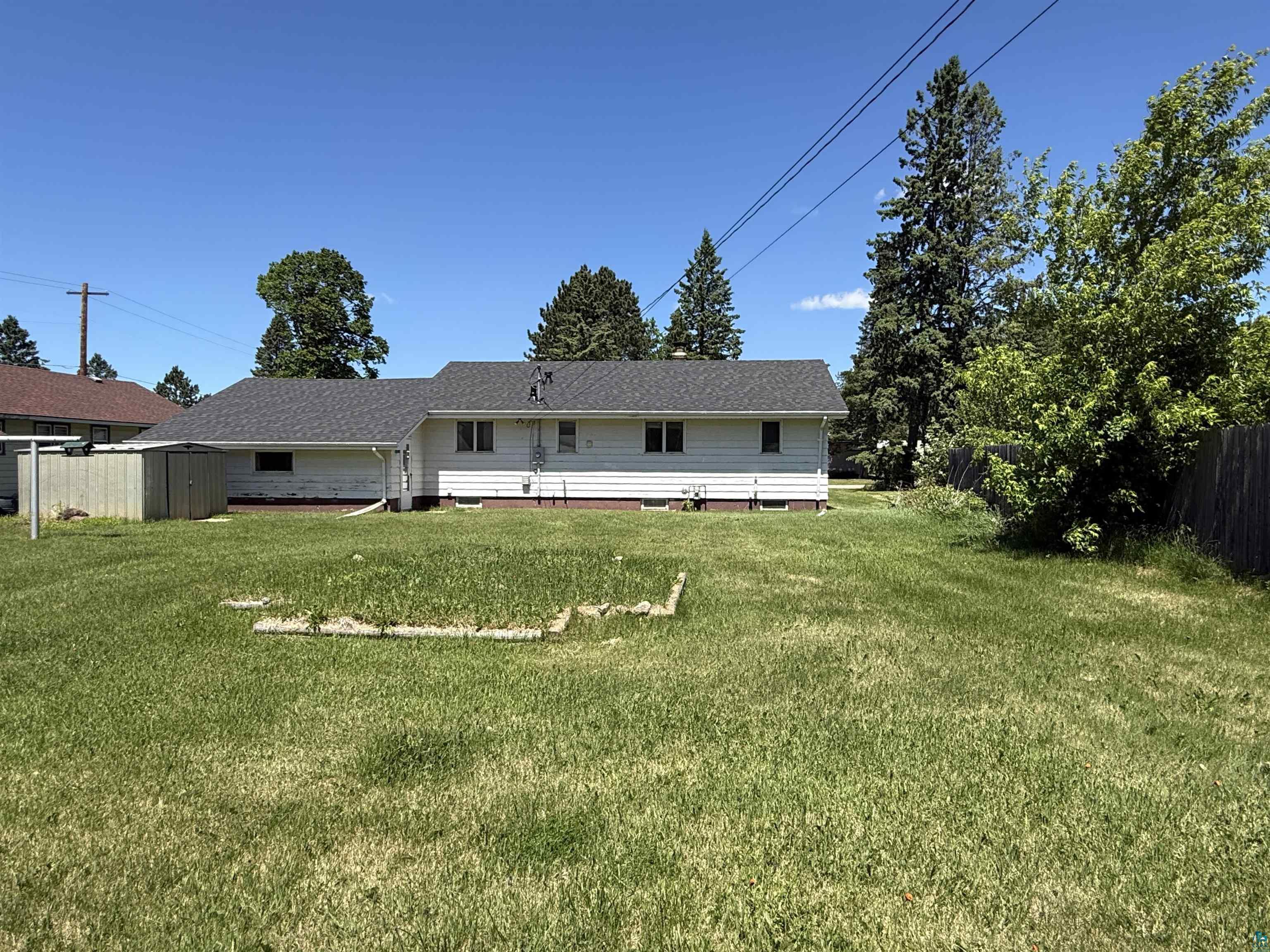 607 3rd Street Northeast Chisholm, MN 55719 - Photo 31 of 32 Spacious rear yard with a perimeter fence and mature trees