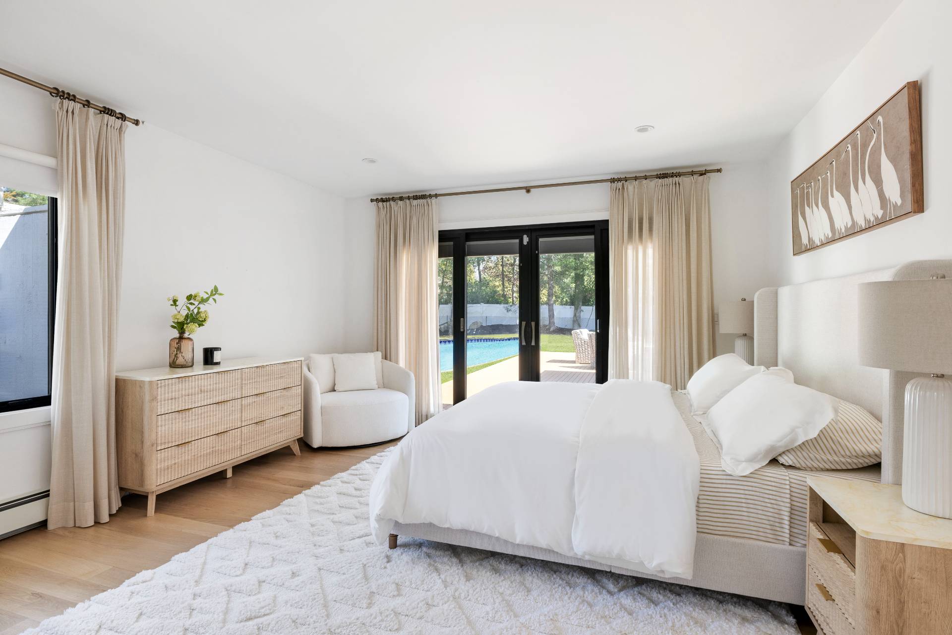 1 High Point Road East Hampton, NY 11937 - Photo 10 of 18 a large white bed sitting in a bedroom next to a window with a dresser
