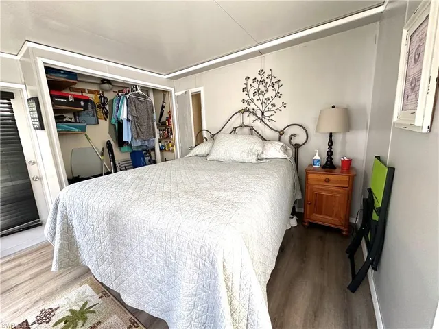 a bedroom with a bed and a mirror on the dresser