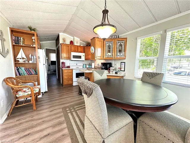 a dining room with furniture a chandelier and wooden floor