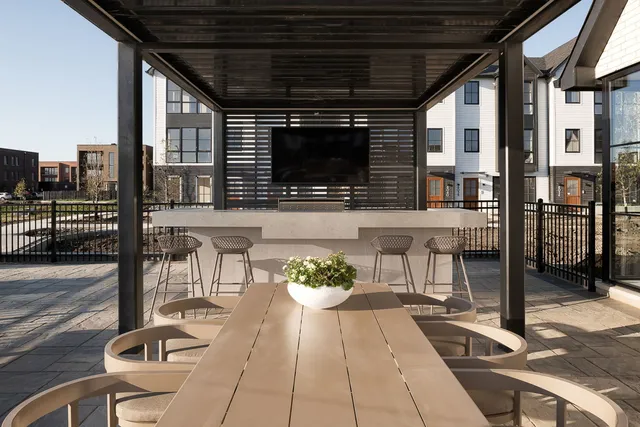 a roof deck with table and chairs and wooden floor