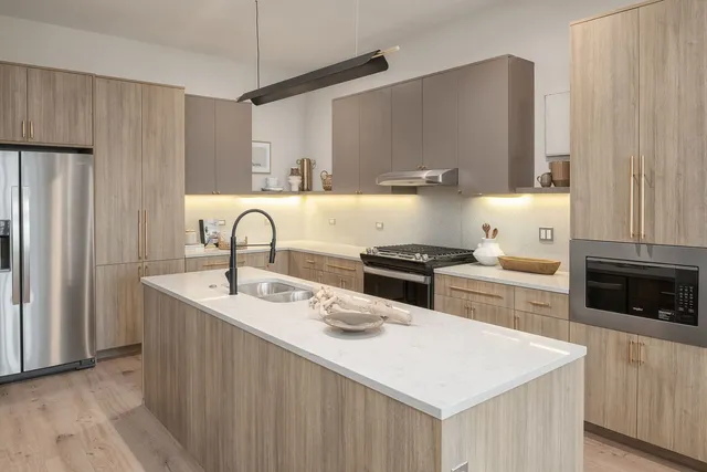a room with lots of white furniture and wooden floor
