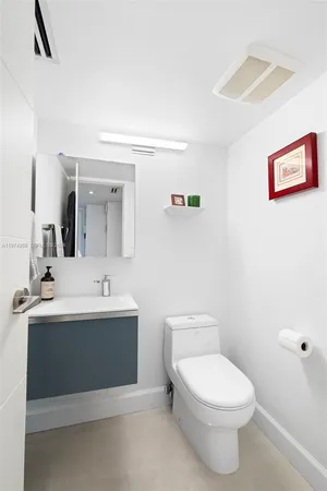 a bathroom with a toilet a sink and mirror