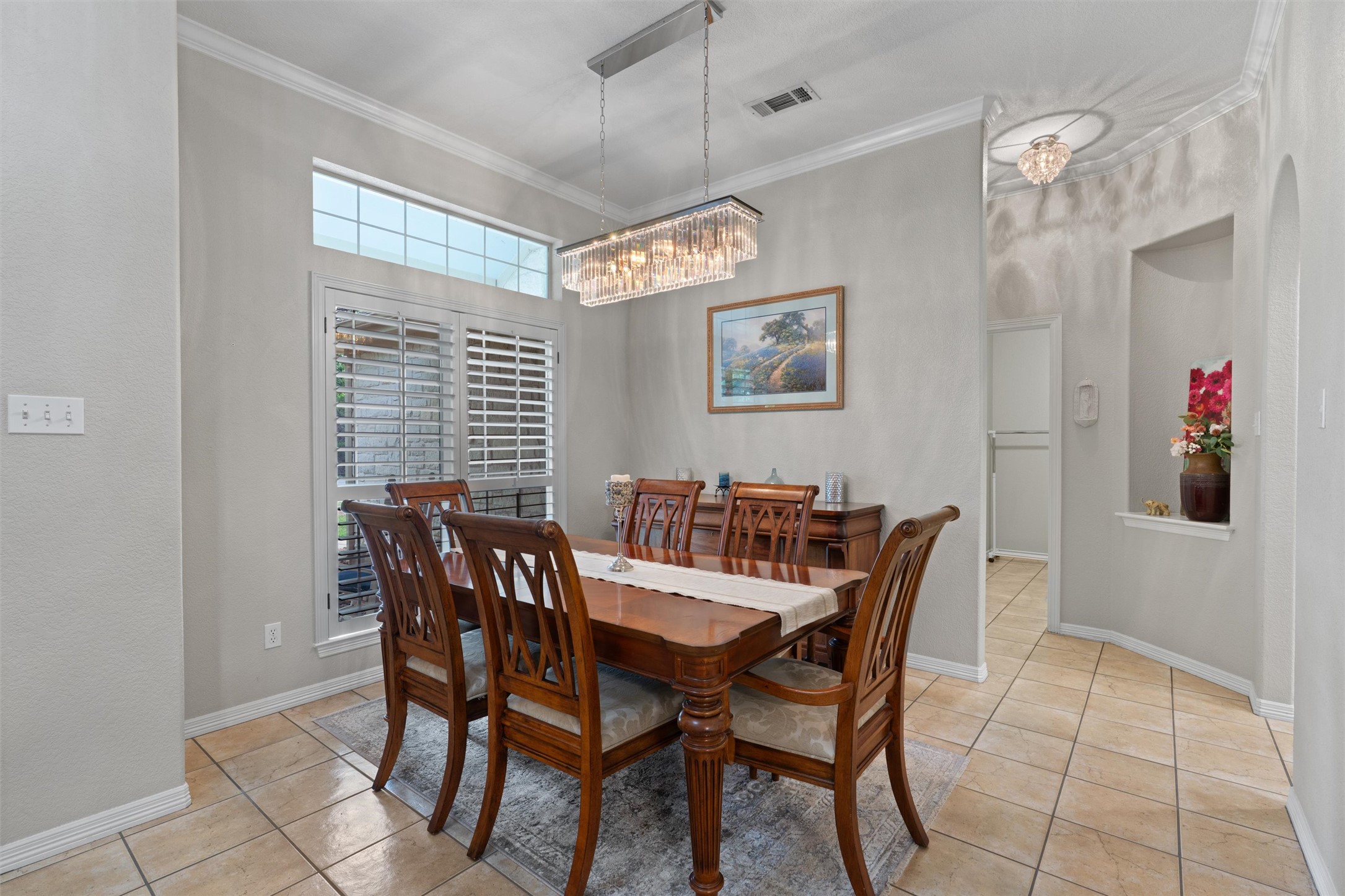 223 East Ridgewood Road Georgetown, TX 78633 - Photo 6 of 40 Formal dining area features a stylish rectangular chandelier, crown molding, and plantation shutters