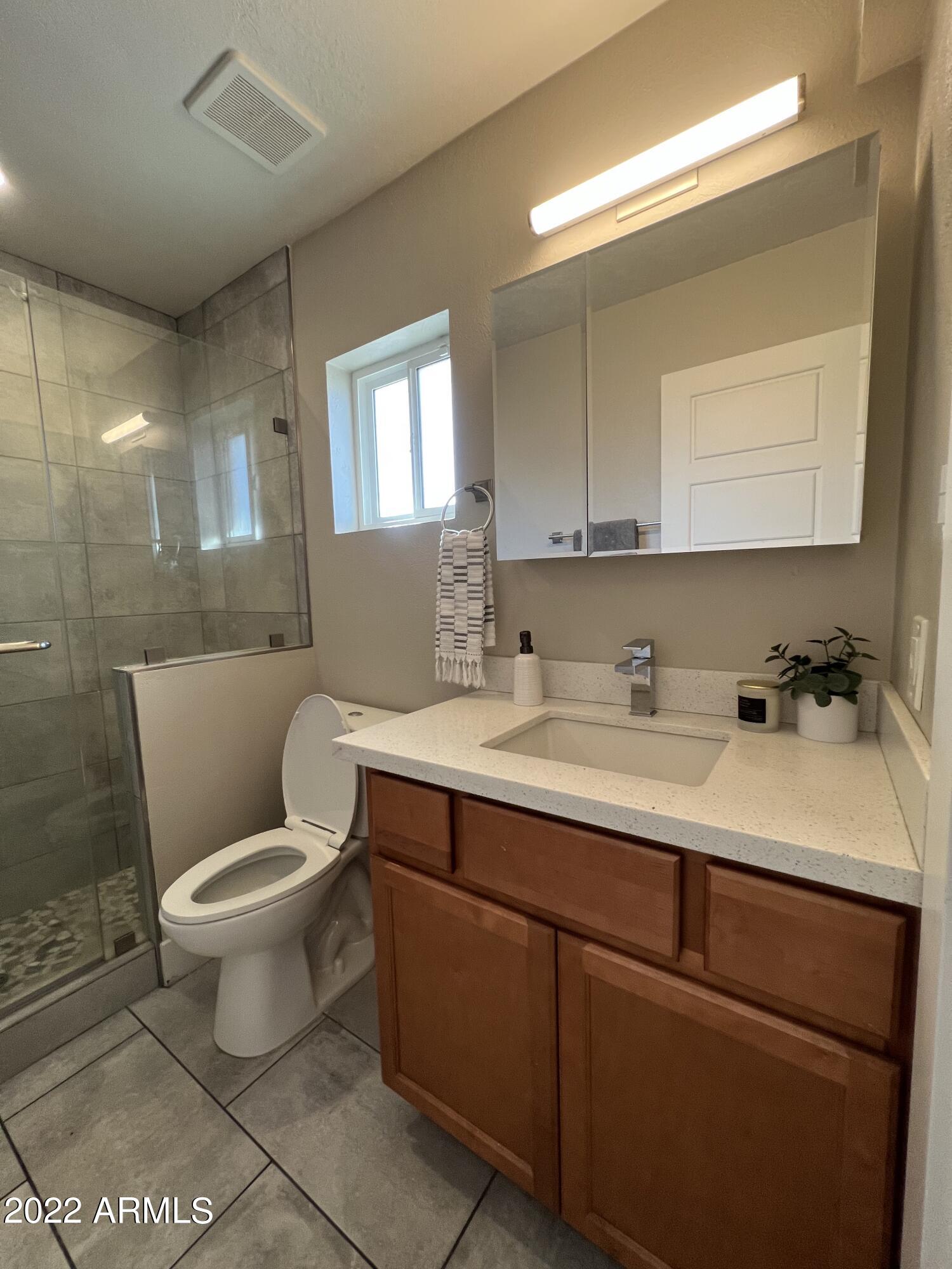 1250 East Bethany Home Road, Unit 17 Phoenix, AZ 85014 - Photo 15 of 25 a bathroom with a sink toilet and mirror