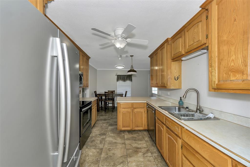 512 Allison Road Springtown, TX 76082 - Photo 11 of 32 a kitchen with sink cabinets and window