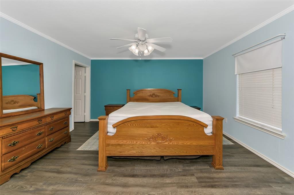 512 Allison Road Springtown, TX 76082 - Photo 15 of 32 a bedroom with a bed and a chandelier