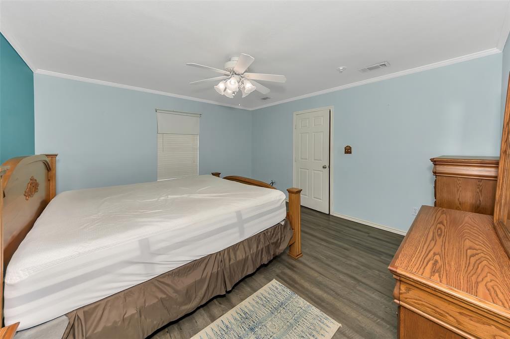 512 Allison Road Springtown, TX 76082 - Photo 16 of 32 a bedroom with a bed and a chandelier