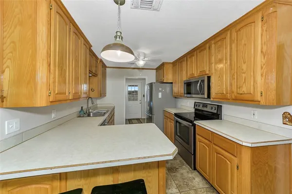 a kitchen with stainless steel appliances a stove a sink a microwave and cabinets