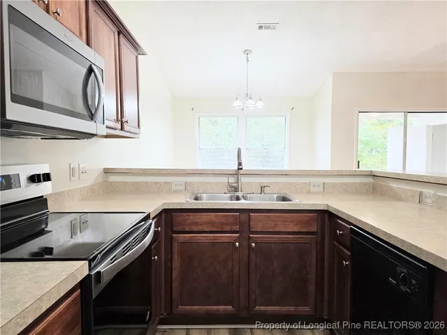 a kitchen with stainless steel appliances granite countertop a sink stove and cabinets