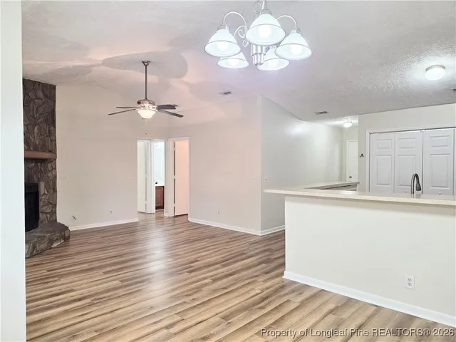 a view of a room with wooden floor and chandelier