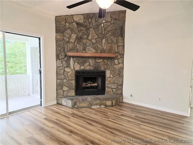 a view of empty room with wooden floor and fireplace