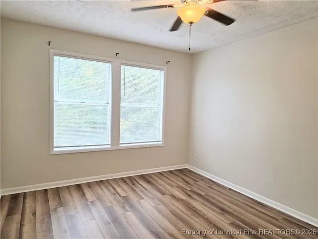 an empty room with a window and wooden floor