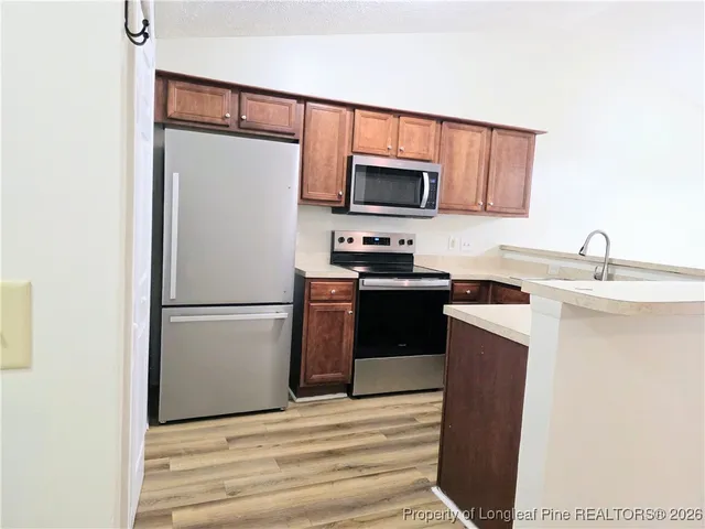 a kitchen with stainless steel appliances a refrigerator sink and microwave