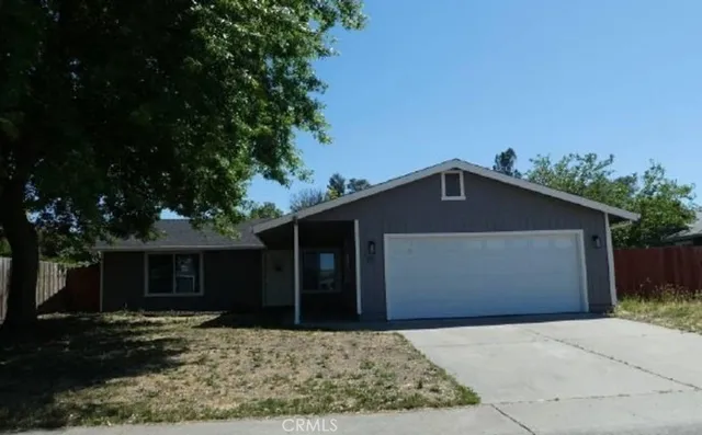 a front view of a house with a yard and trees