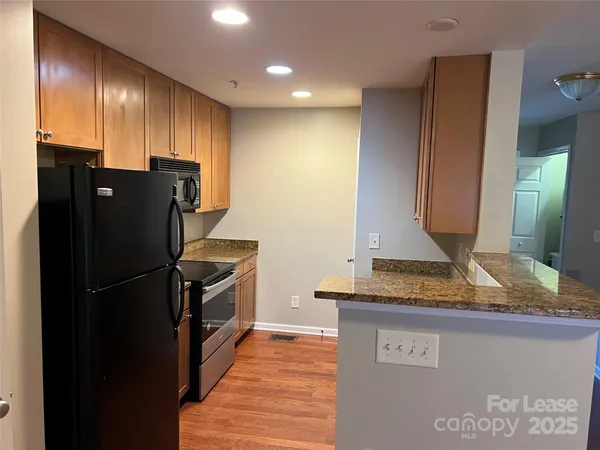 a kitchen with granite countertop a refrigerator and a sink