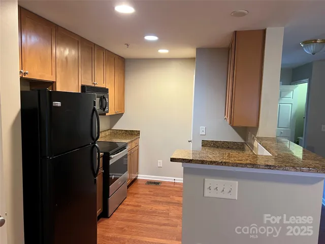a kitchen with granite countertop a refrigerator and a sink