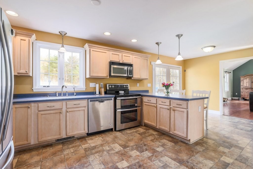 53 Baker Pond Road Charlton, MA 01507 - Photo 11 of 27 a large kitchen with stainless steel appliances granite countertop a stove a sink and a microwave