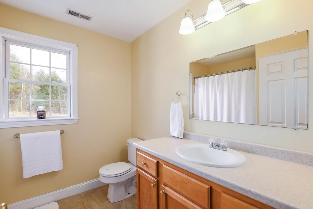 53 Baker Pond Road Charlton, MA 01507 - Photo 21 of 27 a bathroom with a granite countertop sink toilet and mirror