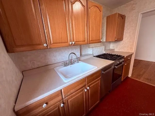 a kitchen with stainless steel appliances granite countertop a sink a stove and a microwave oven